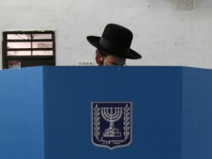 An ultra-Orthodox Jew stands behind a voting booth while casting his ballot at a polling station in Tel Aviv February 10, 2009. Israelis voted on Tuesday in a tight election race, with right-wing opposition leader Benjamin Netanyahu bidding to oust the centrist party of Foreign Minister Tzipi Livni.  REUTERS/Gil Cohen Magen (ISRAEL)